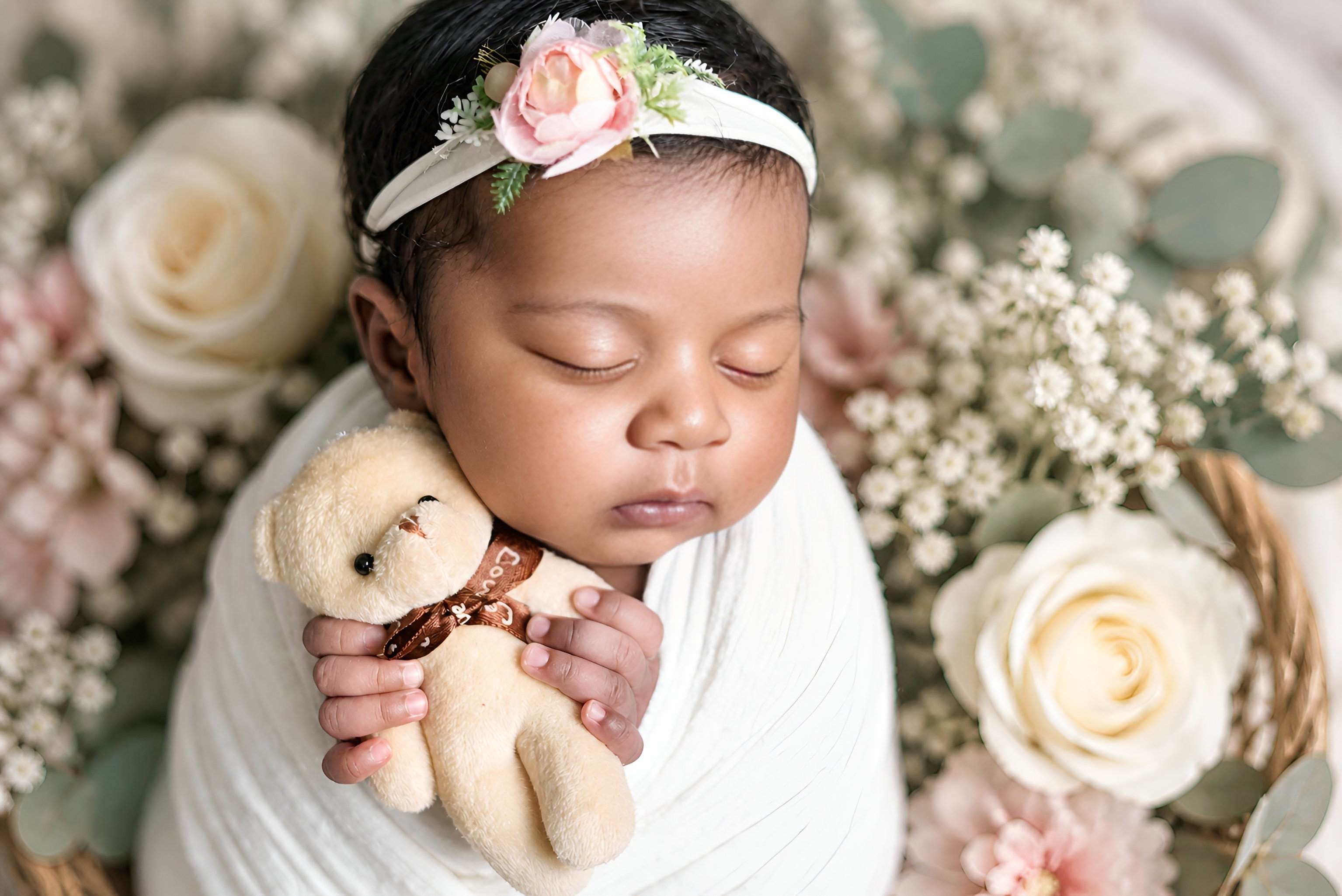 Newborn baby holding teddy bear — intimate close-up newborn photography Dubai